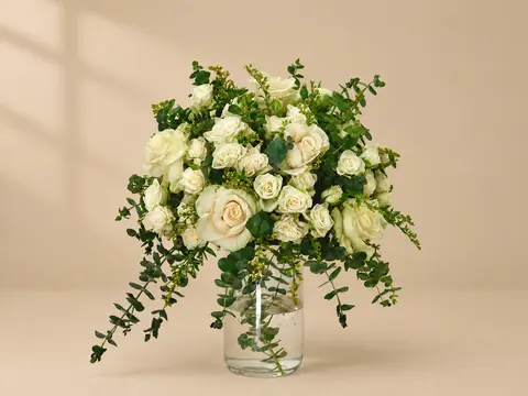 Ivory roses with trailing greens