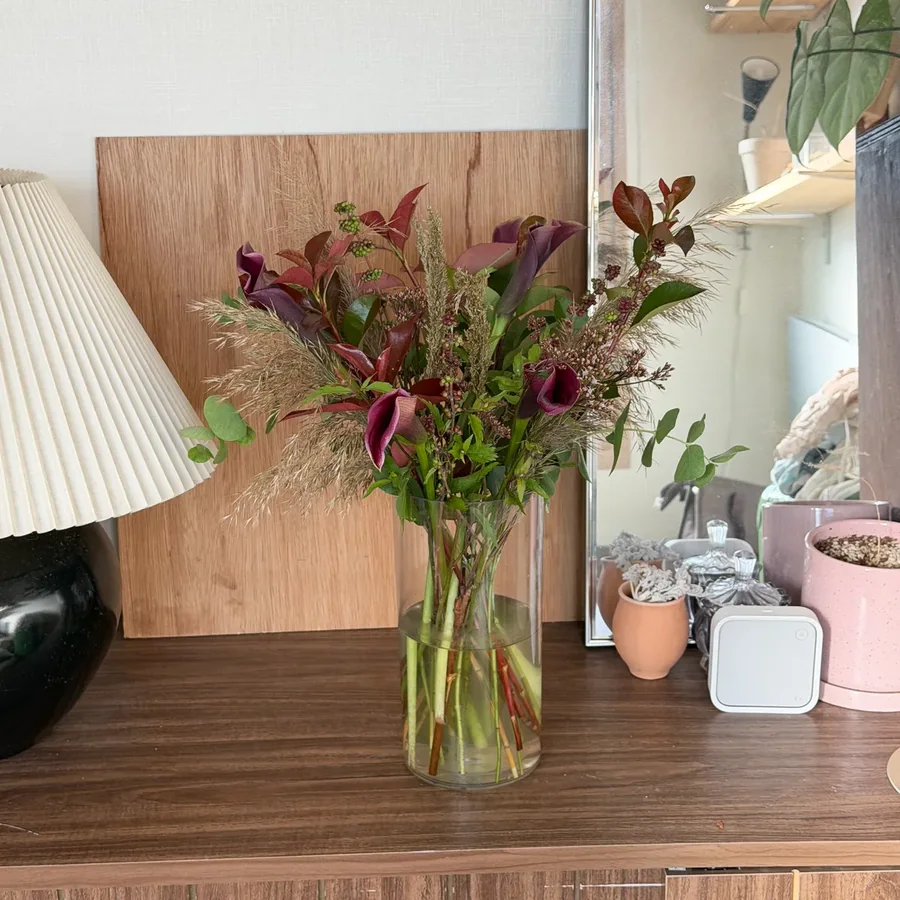 Burgundy calla with grasses and red leaves
